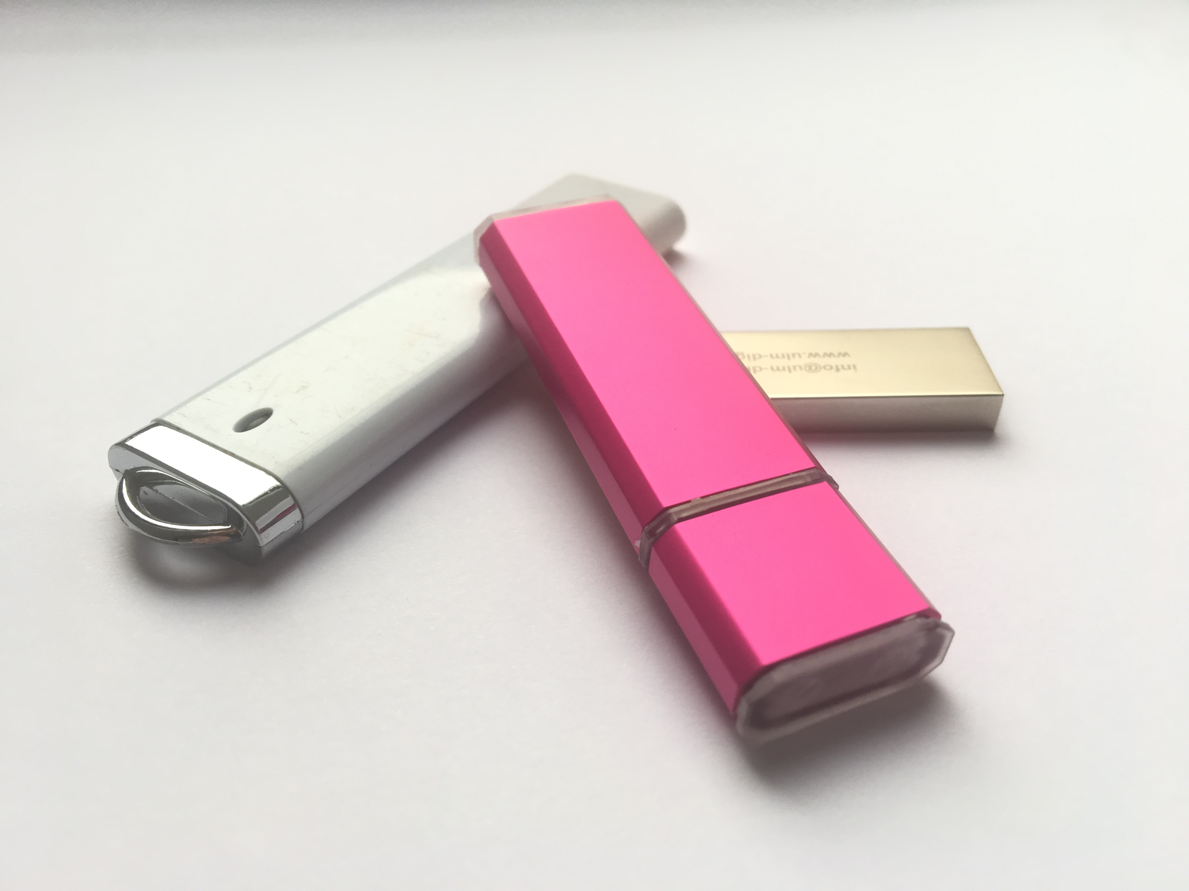Tres memorias USB-A de distintos colores y diseños.