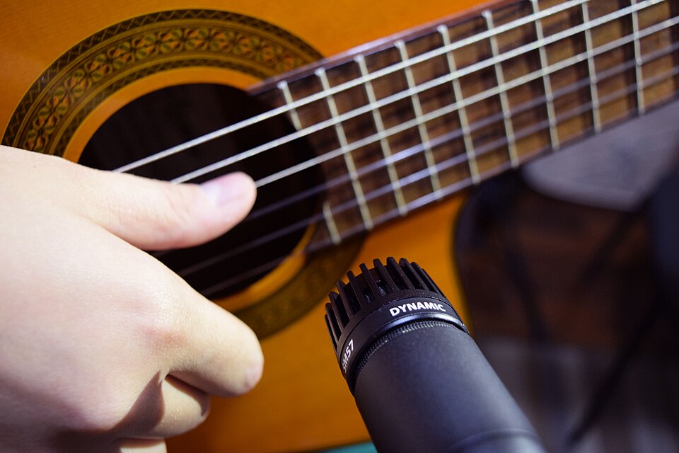 Micrófono dinámico de instrumento apuntando a una guitarra.