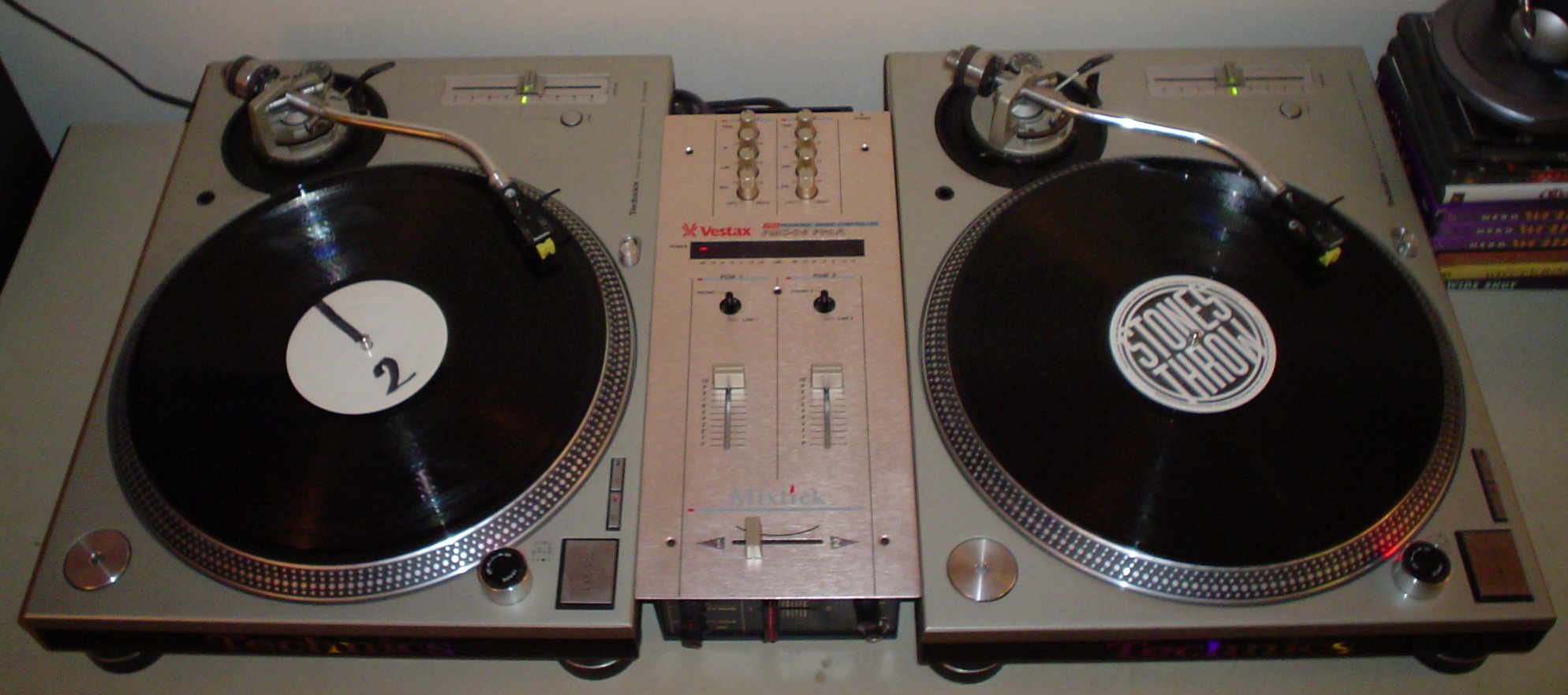 Dos tocadiscos para DJ conectados a una mixer de dos canales.